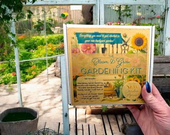 May include: A gardening kit box with a yellow and brown design. The box features a gardening apron, tools, and a packet of flower seeds. The text on the box reads "The Bloom & Grow Gardening Kit".
