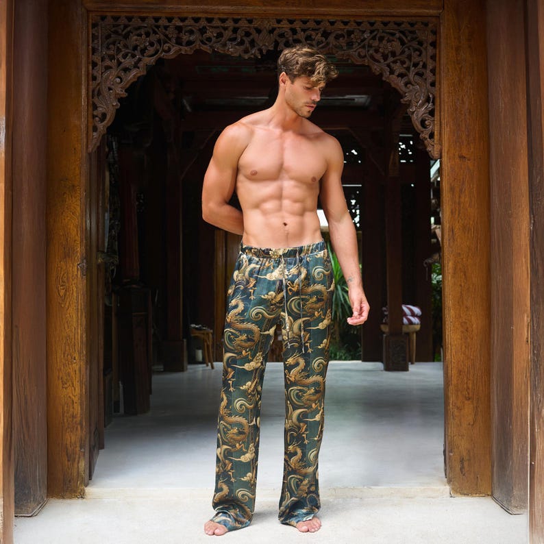 May include: Green and gold dragon print pajama pants. The pants have a drawstring waist and a loose fit. The dragon design is repeated throughout the fabric. The pants are made of a silky material.