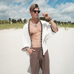 Africano-inspired men’s kimono jacket, perfect for beachwear, festivals, and casual outings. Bold, unique design made from natural fabrics. Lightweight, breathable, and ideal for warm weather. Stand out with this retro-style piece.