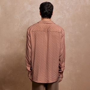 May include: A long-sleeved button-down shirt with a geometric pattern in shades of brown and white.