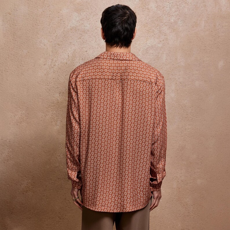 May include: A long-sleeved button-down shirt with a geometric pattern in shades of brown and white.