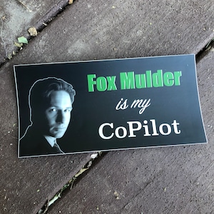 May include: Black and white sticker with a photo of Fox Mulder from the X-Files. The text reads "Fox Mulder is my CoPilot" in green and white.
