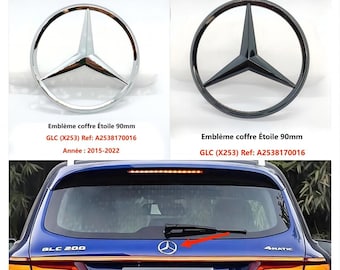 May include: Two close-up images of a silver and black Mercedes-Benz star emblem. The emblem is 90mm in diameter and is designed for the trunk of a Mercedes-Benz GLC (X253) model. The text "Emblème coffre Étoile 90mm" is visible in the image. The text "GLC (X253) Ref: A2538170016" is visible in the image. The text "Année: 2015-2022" is visible in the image. The third image shows a blue Mercedes-Benz GLC (X253) with the silver star emblem on the trunk.