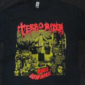 May include: Black t-shirt featuring a yellow and red graphic print of a band called "Terrorizer". The graphic depicts a figure of Jesus Christ with the words "World Downfall" underneath.