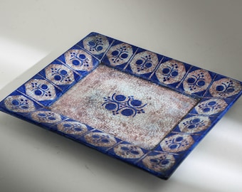 May include: Square ceramic serving dish with a blue border and a central design. The border features a repeating pattern of blue and white floral motifs. The center has a cracked, aged appearance with a blue floral design.
