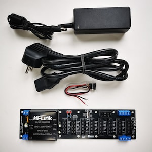 May include: An assortment of electronic components, including a black DC/DC converter, power supply, and a circuit board. The circuit board has multiple ports and the text "Hi-Link DC/DC Converter". Cables and a small switch are also included.