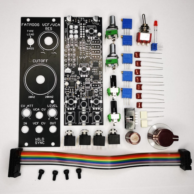 Puede incluir: Un conjunto de componentes electr&oacute;nicos para un proyecto de bricolaje, que incluye placas de circuito impreso negras, potenci&oacute;metros, interruptores y un cable de cinta multicolor. Los componentes est&aacute;n dispuestos sobre una superficie blanca, listos para el montaje.