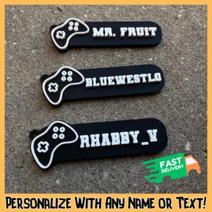 May include: Three black name tags with white text and a white controller design. The names on the tags are "MR. FRUIT", "BLUEWESTLO", and "RHABBY_V". The image also includes the text "PERSONALIZE WITH ANY NAME OR TEXT!"