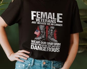 May include: Black t-shirt with the text "FEMALE VETERANS" and the phrase "WEAR OUR UNIFORM DOESN'T MEAN WE ARE ANY LESS DANGEROUS". The design includes an American flag and combat boots.
