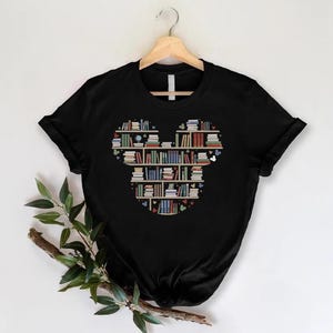 May include: Black t-shirt with a graphic of a bookshelf shaped like Mickey Mouse's head. The books on the shelves are various colors and have different titles.
