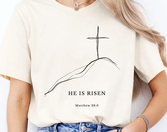 Camiseta «Él ha resucitado», camiseta cristiana de Pascua, camiseta minimalista con cruz, camiseta con versículo bíblico Mateo 28:6, camiseta con temática religiosa, atuendo religioso de Pascua.