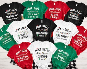 May include: A collection of Christmas-themed t-shirts in various colors, including black, white, red, and green. Each shirt features the phrase "Most Likely" followed by a humorous Christmas-related statement, such as "to sing the Christmas songs."