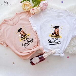 May include: Two white t-shirts with a photo of a graduate and the text "Proud Mom of the Graduate" and "Proud Dad of the Graduate".
