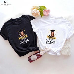 May include: Two black and white t-shirts with a photo of a graduate and the text "Proud Mom of the Graduate" and "Proud Dad of the Graduate".