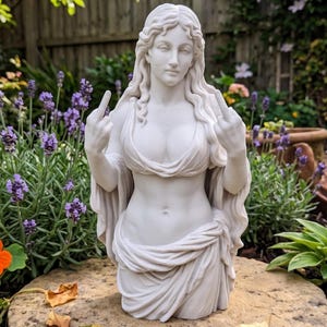 May include: A white marble statue of a woman with long flowing hair, gesturing with both hands. The statue is set in a garden with purple flowers and greenery. The woman is wearing a draped garment.
