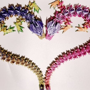Peut inclure: Une forme de c&oelig;ur r&eacute;alis&eacute;e avec des fleurs en tissu de couleur violette, rose, dor&eacute;e et verte. Les fleurs sont dispos&eacute;es en d&eacute;grad&eacute;, les fleurs violettes en haut et les fleurs vertes en bas.