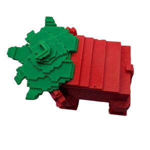 May include: A 3D-printed geometric sculpture in red and green. The sculpture features a stacked rectangular base in red, with a green, layered, star-like shape on top. The design is modern and abstract, suitable for home decor.