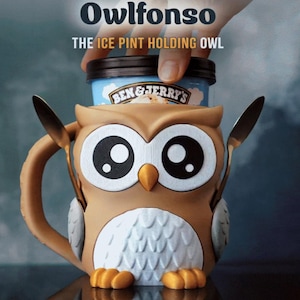 May include: A brown owl-shaped ice cream pint holder with the text "Owlfonso THE ICE PINT HOLDING OWL". The holder has large black and white eyes, a yellow beak, and a white chest. A pint of Ben & Jerry's ice cream is inside the holder.