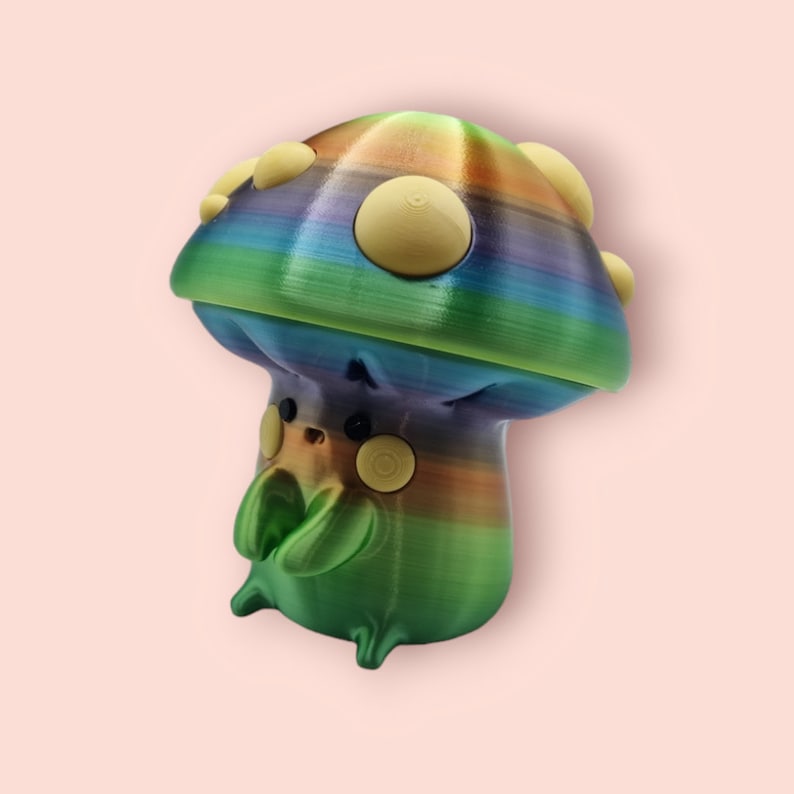 May include: A rainbow-colored mushroom-shaped figurine with a green body and yellow spots. The figurine has a whimsical and playful design.