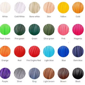 K&ouml;nnte beinhalten: Eine Farbkarte mit 24 verschiedenen Farben f&uuml;r 3D-Druck-Filamente. Zu den Farben geh&ouml;ren Wei&szlig;, Gelb, Gr&uuml;n, Rosa, Orange, Blau, Lila, Silber und Schwarz. Jede Farbe ist mit ihrem Namen beschriftet.