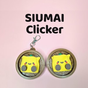 Puede incluir: Dos llaveros Siu Mai Clicker con un diseño de dumpling amarillo, cada uno con una cara sonriente y detalles grises, colocados en cestas circulares marrones. Los llaveros tienen un cierre plateado sobre un fondo rosa. Texto: 'SIUMAI Clicker'.