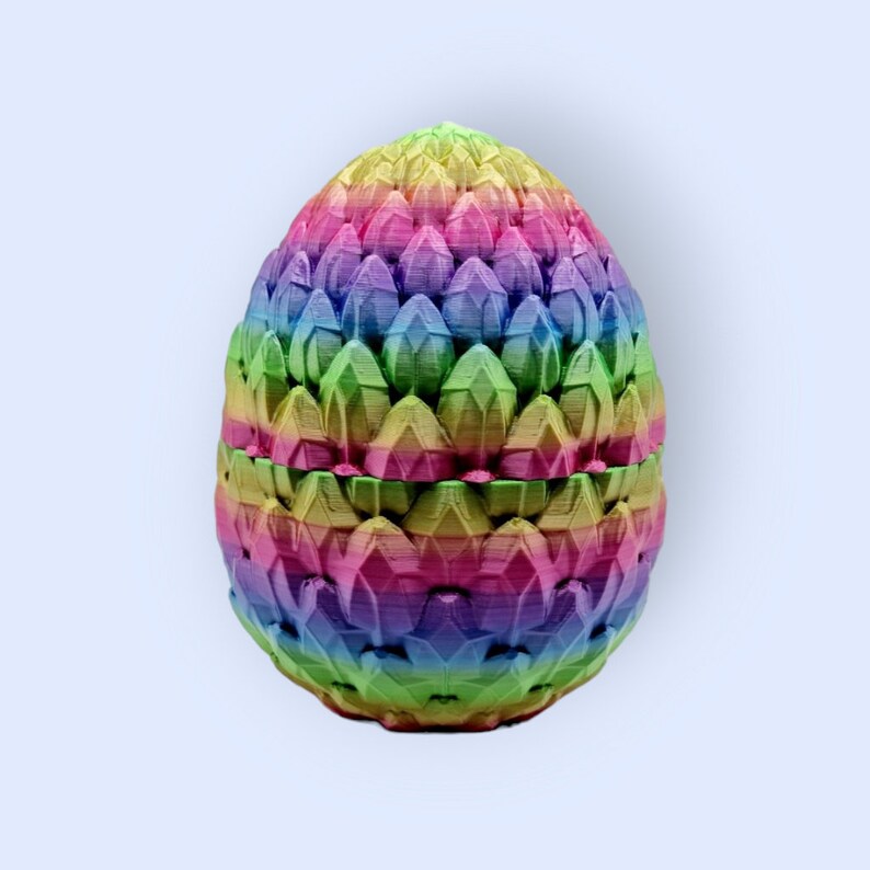 May include: A rainbow-colored dragon egg-shaped trinket box with a textured, scaly surface.