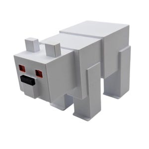 May include: A white, blocky polar bear figurine with red eyes and a black nose. The toy is made of geometric shapes, resembling a pixelated design. The bear has four rectangular legs and two small rectangular ears.