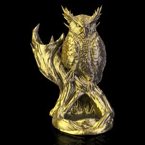 Op de afbeelding: Een gouden uil sculptuur, zittend op een tak. De uil heeft gedetailleerde veertjes en een strenge uitdrukking. De sculptuur staat tegen een zwarte achtergrond, wat de metallic afwerking en het ingewikkelde ontwerp benadrukt.