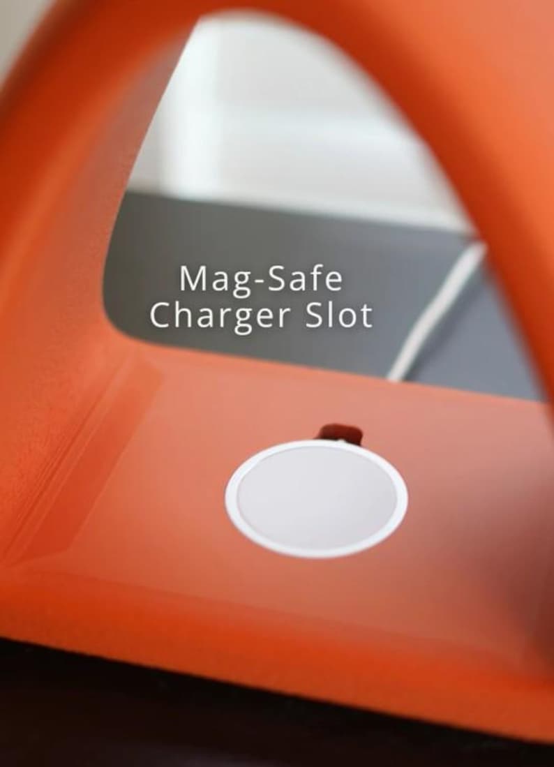May include: Close-up of an orange Mag-Safe charger slot. The charger has a white circular charging pad. The text "Mag-Safe Charger Slot" is printed in white on the background.