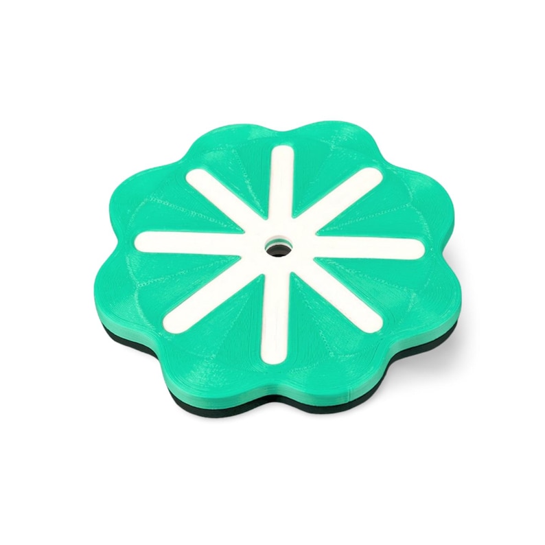 May include: A teal and white coaster with a flower-like design. The coaster has a circular shape with a series of curved edges. White lines radiate from a central hole, creating a starburst pattern. The coaster has a black base.