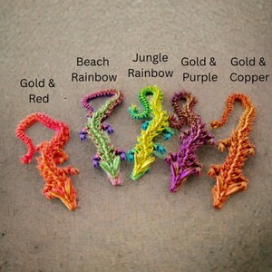 May include: Five origami dragons in different colors: gold and red, beach rainbow, jungle rainbow, gold and purple, and gold and copper.