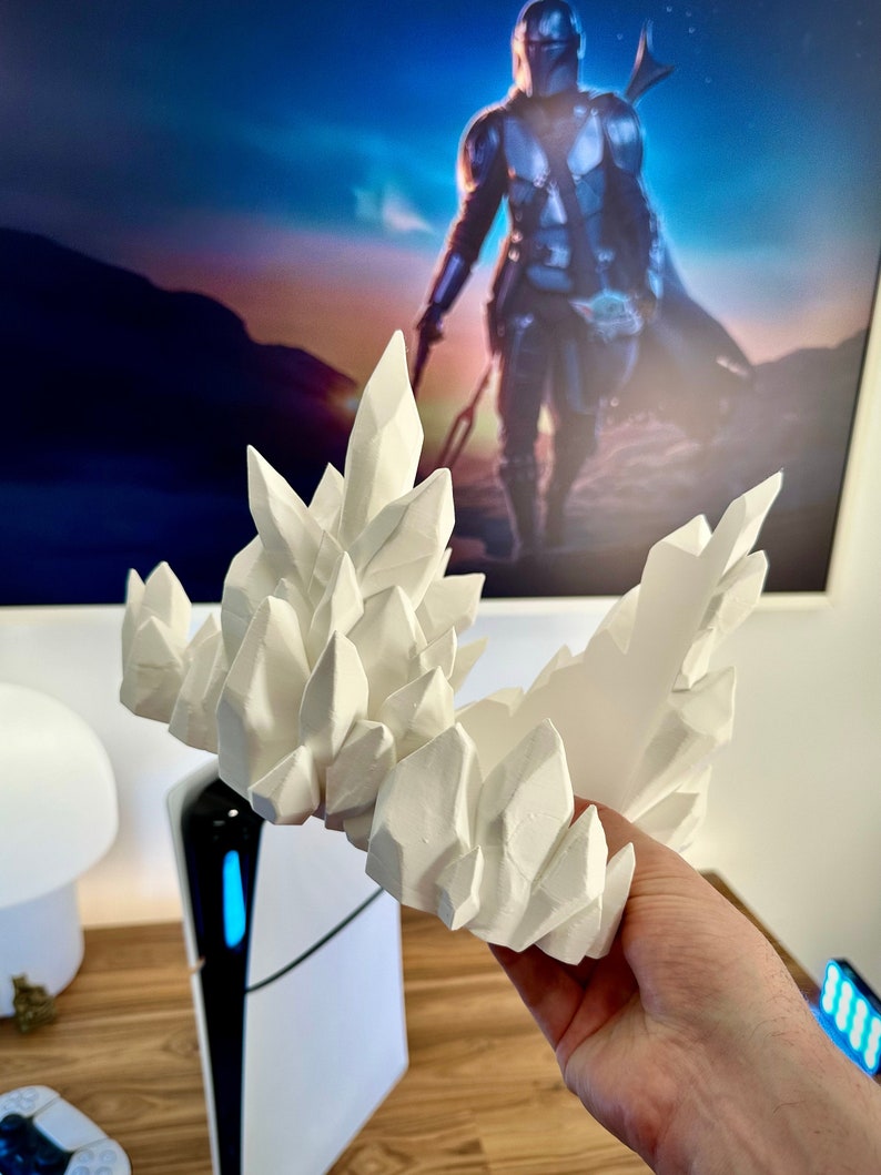 May include: White 3D printed crystal rock formation. The rock formation is made of many individual crystals that are all connected together. The crystals are all different sizes and shapes.