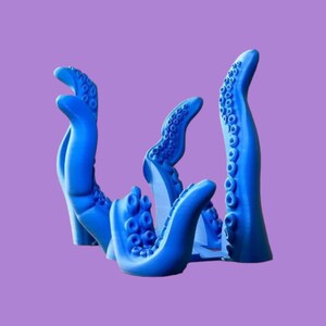 May include: A blue 3D printed octopus tentacle sculpture with multiple arms reaching upwards. The sculpture is made of a smooth, glossy material.