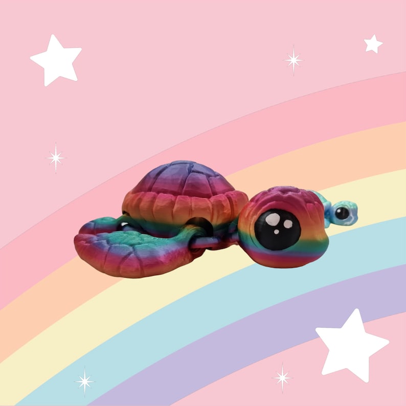 Puede incluir: Una figurita de tortuga de color arco&iacute;ris con una peque&ntilde;a tortuga azul unida a su cola. La tortuga est&aacute; hecha de un material liso y brillante y tiene una cara linda y de estilo de dibujos animados.