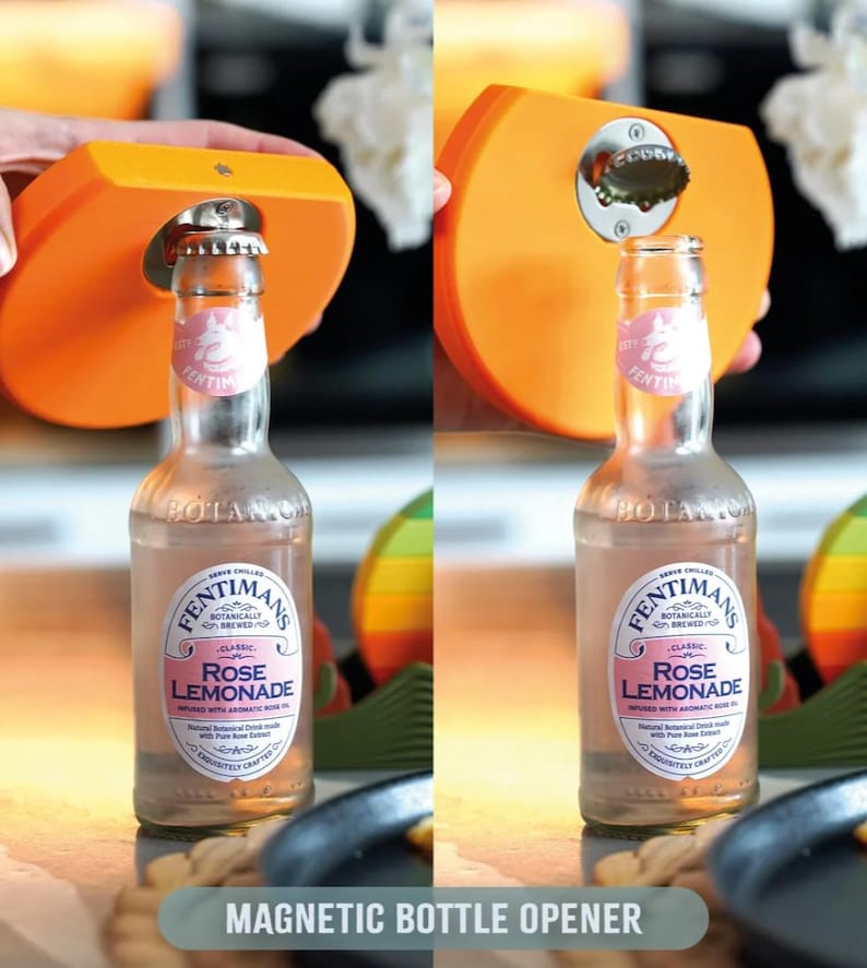 May include: An orange magnetic bottle opener is used to open a bottle of Rose Lemonade. The bottle has a pink label with the text "Rose Lemonade". The words "Magnetic Bottle Opener" are at the bottom of the image.