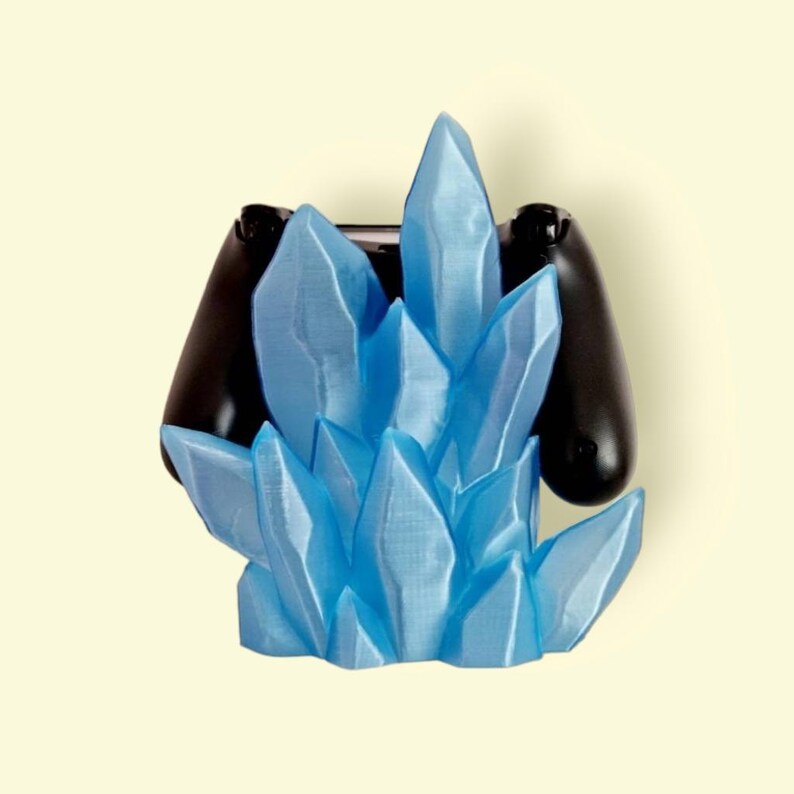 May include: A blue crystal-shaped video game controller holder. The holder is made of plastic and has a frosted finish. The controller is not included.