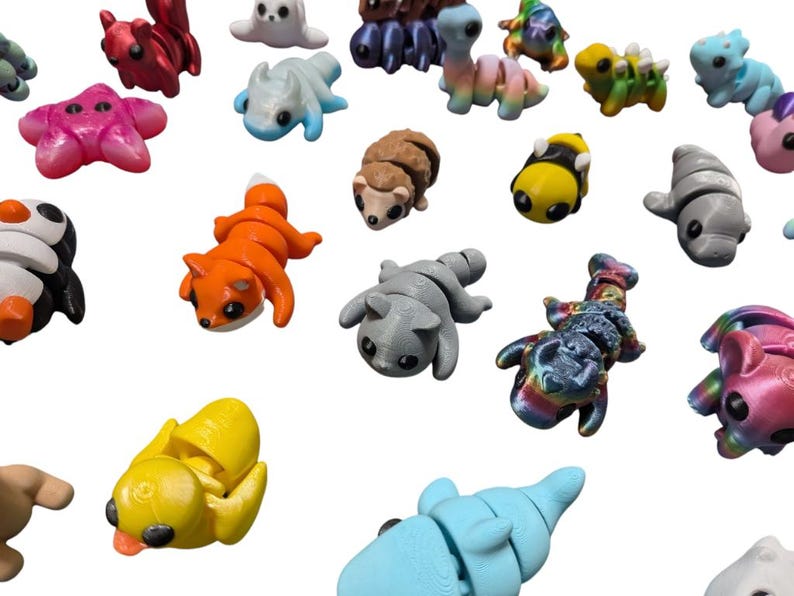 Peut inclure: Une collection de figurines d'animaux miniatures color&eacute;es. L'assortiment comprend un renard, un pingouin, une abeille et d'autres cr&eacute;atures dans diverses couleurs comme l'orange, le jaune et le bleu. Ces petites figurines d&eacute;taill&eacute;es sont probablement des jouets ou des objets d&eacute;coratifs.