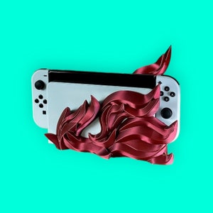 May include: A white Nintendo Switch console with a red and pink 3D printed design. The design resembles a stylized flame or flower.