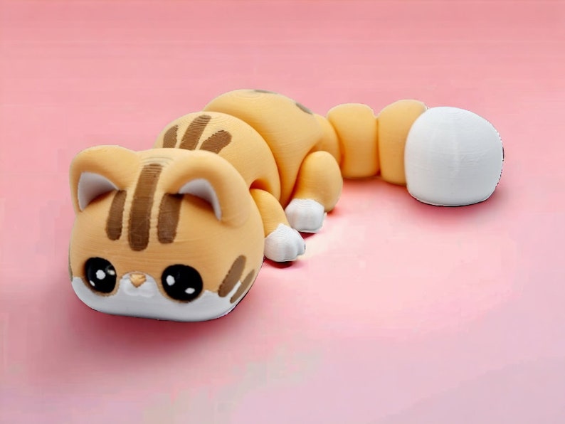 May include: A small, orange and brown cat figurine with large eyes and a white tail. The figurine is made of a smooth, plastic-like material.