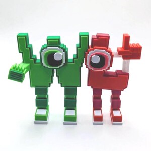 May include: Two pixelated figures, one green and one red, stand side-by-side. The green figure has a hand with a comb-like structure, while the red figure has a hand raised in a thumbs-up gesture. Both have large, round eyes.