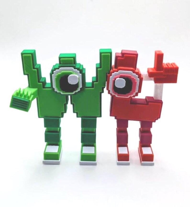 May include: Two pixelated figures, one green and one red, stand side-by-side. The green figure has a hand with a comb-like structure, while the red figure has a hand raised in a thumbs-up gesture. Both have large, round eyes.
