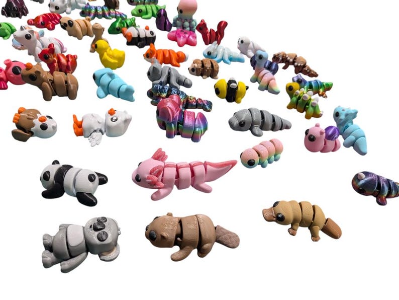 Peut inclure: Une collection de figurines d'animaux segment&eacute;s color&eacute;s, dont des pandas, des axolotls et des chenilles. Les figurines sont de diff&eacute;rentes couleurs, comme le rose, le marron et le bleu, et sont dispos&eacute;es sur un fond blanc. Ces jouets conviennent aux enfants.