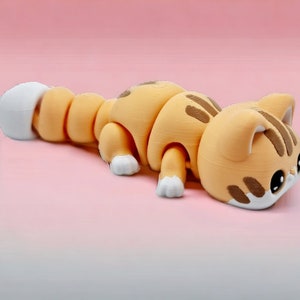 May include: A segmented, orange and white, 3D printed cat figurine with a white tail. The cat is lying on its belly with its head turned to the side.