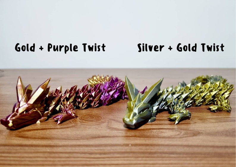 Peut inclure: Deux dragons en origami, l'un avec des &eacute;cailles dor&eacute;es et violettes, l'autre avec des &eacute;cailles argent&eacute;es et dor&eacute;es. Les dragons sont couch&eacute;s sur une surface en bois. Le texte "Gold + Purple Twist" est au-dessus du premier dragon, et le texte "Silver + Gold Twist" est au-dessus du deuxi&egrave;me dragon.