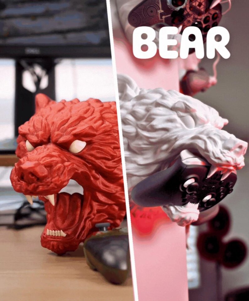 May include: A red and white bear-shaped gaming controller holder. The red bear has an open mouth with visible teeth. The white bear holds a black controller in its mouth. The word "BEAR" is written in white letters.