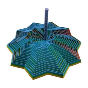May include: A layered, star-shaped sculpture with a central, ridged post. The sculpture features multiple layers of blue, green, and orange hues, creating a gradient effect. The design has a geometric, modern aesthetic.