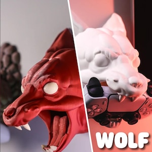 Könnte beinhalten: Ein 3D-gedruckter Wolfskopf-Wandhalter in Rot und Weiß. Der Wolfskopf ist so konzipiert, dass er einen Videospiel-Controller hält. Der Text "WOLF" ist in Weiß auf rotem Hintergrund gedruckt.