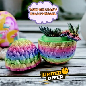 May include: A rainbow dragon fidget toy inside a colorful egg-shaped container. The container is open and the dragon is visible. The text "FREE MYSTERY FIDGET MODEL" is in a purple cloud above the container. The text "LIMITED OFFER" is in a yellow circle below the container.