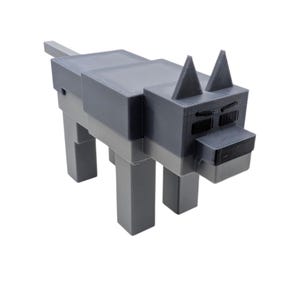 May include: A grey and light grey blocky wolf figurine. The wolf has a rectangular body, legs, and head, with triangular ears and a small tail. The eyes and nose are black. The figurine is likely 3D-printed.