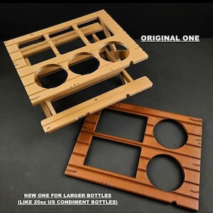 May include: Two wooden bottle holders, one with six slots and the other with three slots. The larger holder is labeled "NEW ONE FOR LARGER BOTTLES (LIKE 20oz US CONDIMENT BOTTLES)". The smaller holder is labeled "ORIGINAL ONE".